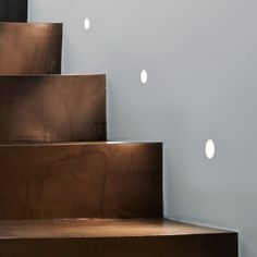 there are several white circles on the wall next to some brown and white stairs in this room