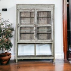 an old wooden cabinet next to a potted plant