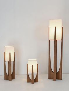 three wooden sculptures with one light on each side