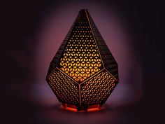 a lamp that is lit up in the dark with an intricate design on it's side