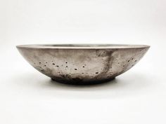 a silver bowl sitting on top of a white table