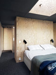 a large bed in a bedroom next to a wall with wood paneling on it