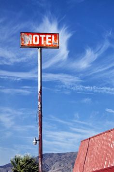 an old motel sign on top of a red building