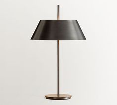 a lamp that is on top of a wooden base and has a black shade over it