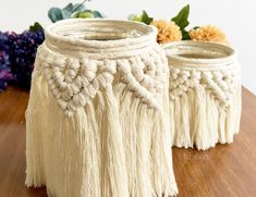 two white vases sitting on top of a wooden table