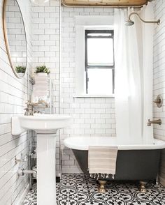 a black and white bathroom with a claw foot tub