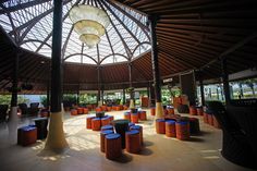 the inside of a building with orange and blue stools on the concrete flooring