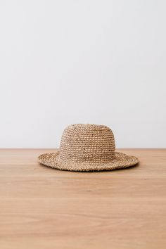 Front view of Handwoven Hat on an Oak Dining Table Against a White Wall. - Saffron and Poe Holiday Abroad, Water Hyacinth, Bucket Hats, Balinese, Bucket Hat, Bali, The Sun, The Beach, Hand Weaving