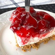 a piece of cake on a plate with a fork stuck in the top and topped with cherries