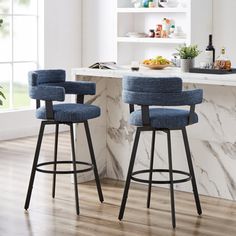 two blue stools sitting in front of a marble counter