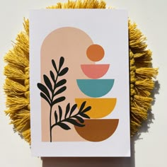 a card with an abstract design on the front and bottom, surrounded by yellow tassels