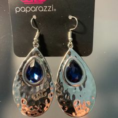 Paparazzi Tranquil Trove Blue Earrings With Fish Hook Fittings A Shiny Silver Teardrop Is Hammered In Texture, Creating A Radiant Display As The Light Bounces Off Each Beveled Surface. A Faceted Blue Teardrop Gem Is Pressed Into The Top Of The Silver Frame In An Enchanting Finish. Formal Blue Metal Earrings, Blue Teardrop Jewelry For Party, Teardrop Blue Jewelry For Party, Blue Teardrop Earrings For Party, Blue Metal Drop Earrings, Elegant Metal Jewelry With Hook Closure, Blue Metal Teardrop Earrings Gift, Blue Dangle Teardrop Earrings, Elegant Metal Jewelry With Fish Hook