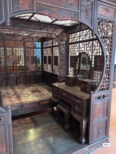 an ornate wooden room divider with mirrors and drawers