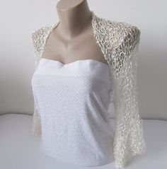 a mannequin wearing a white top and lacy shawl over it's shoulders