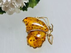 A beautifully handcrafted Baltic amber butterfly brooch set in real 10K yellow Gold.Each amber stone is carefully  shaped and polished to perfection , separated by the gold frame .The gorgeous amber gemstone ,houses several natural flakes ,product of nature ,a tru historic time capsule created over 45 million years ago.Elegant and very unique amber jewelry perfect solution to complement everyday look. Material : Genuine Baltic Amber with Real Yellow 10K gold Color  :  Classic -Honey Dimensions Amber Brooch Jewelry Gift, Copper Plating, Amber Gemstone, Gold Brooch, Professional Jewelry, Amber Stone, Butterfly Brooch, Gold Brooches, Amber Jewelry