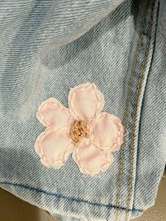 a pink flower is on the back of a pair of jeans