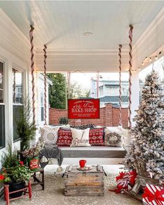 a porch decorated for christmas with red and white decorations