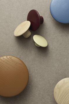 three different colored wooden buttons laying next to each other on a table with grey background