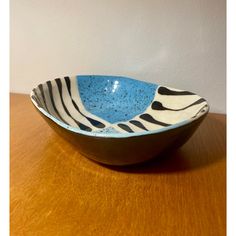 a blue and white bowl sitting on top of a wooden table