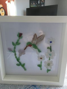 a white frame with flowers and leaves in it