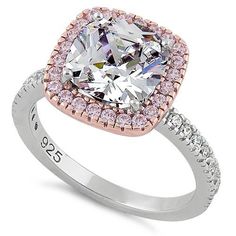 an engagement ring with a cushion cut diamond surrounded by pink and white cubicnes on the sides