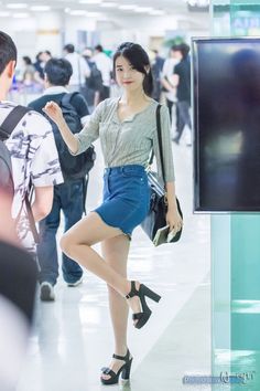 a woman standing in an airport with her hand on her hip