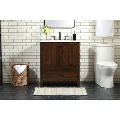 a white toilet sitting next to a wooden cabinet and sink in a bathroom under a mirror