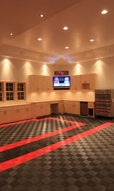 an empty kitchen with black and white checkered flooring in the center, lights on