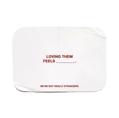 a white coaster with the words loving them feels written on it and red lettering underneath