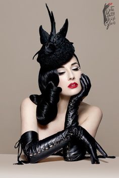 a woman in black gloves and a hat with horns on her head is posing for the camera