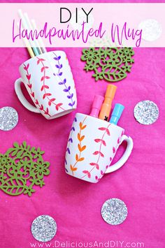 diy handpainted mugs with markers, pens and paper flowers on a pink background