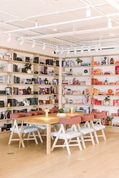 a room with many bookshelves filled with books and various chairs around a table