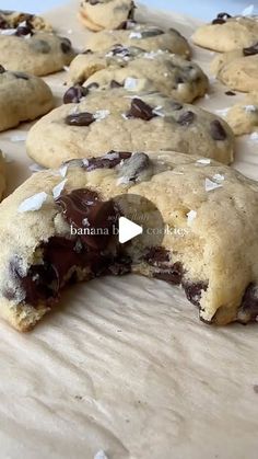 chocolate chip cookies are on a baking sheet and have been cut open to show the inside