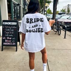 a woman is walking down the sidewalk while wearing a t - shirt that says bride and bougie