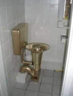 a bathroom with a sink and toilet in it's stall, next to a tiled wall