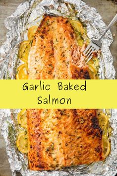 salmon baked in foil with lemons and garlic on the side for garnish