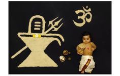 a small child laying on top of a rug next to a wall with symbols painted on it