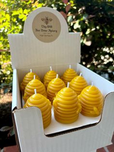 some yellow candles are in a white box