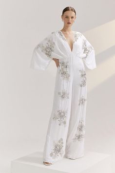 Part of The Royal School of Needlework x Coast collection. Designed with modern brides in mind, this jumpsuit is unbound by tradition. Showing off a wide-leg silhouette with a waist-defining fit and kimono sleeves, the jumpsuit comes complete with sparkling embellishments for extra drama, inspired by the Kyoto artwork. The Royal School of Needlework was founded in 1872, to revive the beautiful artform of embroidery. This new bridal collection has been inspired by the Royal School of Needlework's Archives. Kimono Jumpsuit, Royal School Of Needlework, Royal School, Kimono Sleeves, Kimono Sleeve, Bridal Collection, Kyoto, Needlework, Embellishments