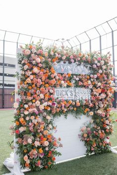 an outdoor ceremony with flowers on the wall