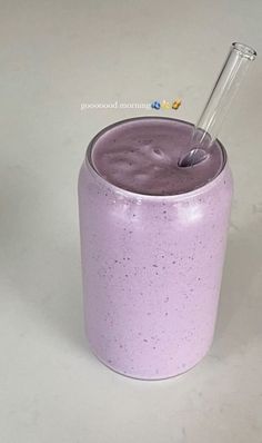 a purple cup with a straw sticking out of it's side, sitting on a white surface