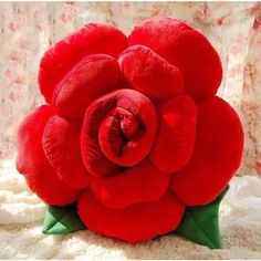 a red flower sitting on top of a white blanket