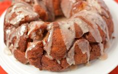 a bundt cake covered in icing on a white plate with a red table cloth