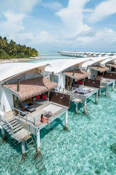 the water is crystal blue and clear with some huts on it's sides that look like they are floating in the ocean