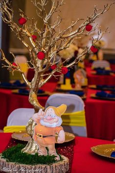 a small tree with apples on it in the middle of a table