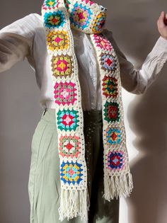 a woman is wearing a crocheted scarf