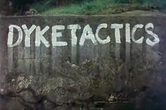 the word dyketactics written in white chalk on a wall