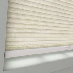 the blinds are closed and there is light coming in from behind them on the window sill