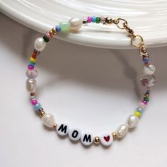 Name bracelet pearls for mom, word bracelet with freshwater pearls, seed beads pearls bracelet gift mom, pearls bracelet, mom gift bracelet These bracelets are made with freshwater pearls beads and seed beads.  Please leave the name or word you want in the Personalization Box. and your size wrist Perfect for this mother's days CARE It is strongly recommended that you avoid exposure of your jewelry to water when swimming or showering. Along with avoiding contact with chemicals or oils when applyi Mom To Be Bracelet, Pearl Bracelet With Letter Beads, Pearl Bracelet With Letter Beads For Gift, Mother's Day Pearl Bracelets, Adjustable Pearl Bracelet For Mother's Day, Mother's Day Gift Beaded Bracelet With Letter Beads, Beaded Pearl Bracelet For Mother's Day, Mother's Day Gift Pearl Beaded Bracelets, Handmade Pearl Bracelet For Mother's Day Gift