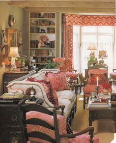 a living room filled with lots of furniture and bookshelves next to a window